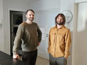 Two males standing next to each other smiling