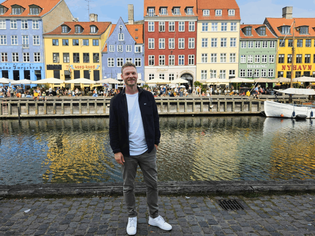 Male standing in front of painted buildings